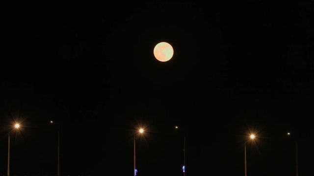 Full moon rises over the bridge. Time-lapse. Road bridge between the cities of Saratov and Engels, Russia. 4K, Ultra HD