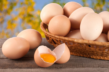 eggs in a wicker basket on a wooden board with blurred garden background