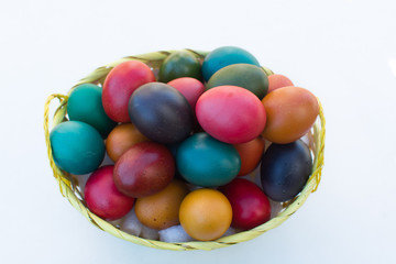 basket of natural easter eggs on white background - top view