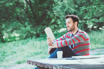 Young man reading a book in the park