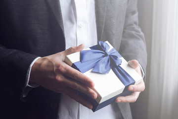 Man offering gift with blue ribbon