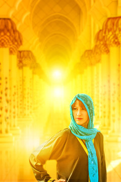 Woman portrait with typical Arab clothes at Sheikh Zayed Grand Mosque at sunset light, the main attraction of Abu Dhabi. Tourism and travel Middle East concept. Blurred architecture background.