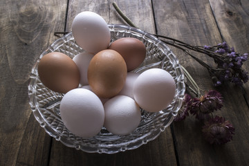Brown and white chicken eggs in glass bowl