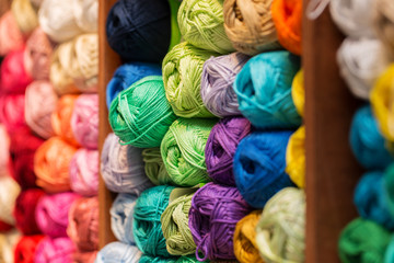 shelves with colorful wool and yarn in a knitting shop - obrazy, fototapety, plakaty