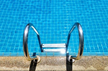 Swimming pool with stair and blue relaxing water