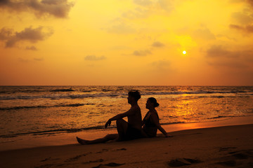 Fototapeta na wymiar Silhouettes of a loving couple on the ocean shore.