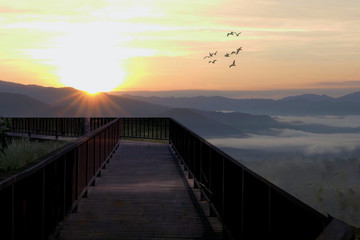 Obraz premium Panoramic view of a mountain in autumn with a foggy at sunrise