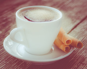 Cup of coffee with cookies on wooden table