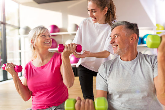 Senior couple training in the gym with a personal trainer
