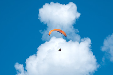 Paragliding in the blue sunny sky. One paraglider fly in summer sunny day in the clouds....