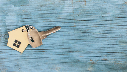 Symbol of the house with silver key on vintage wooden background