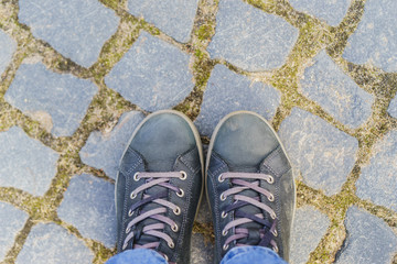 human legs standing on cobblestones