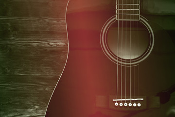 Black acoustic guitar on wooden background