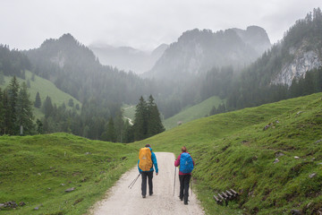 2 Wanderer im Regen auf einem Weg im Berchtesgadener Land, Bayern - obrazy, fototapety, plakaty