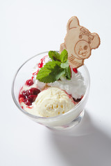 Fresh ice cream with jam in a glass bowl close up.