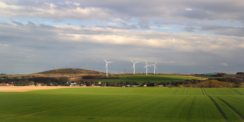 Fototapeta premium Alternative energy with windmills at a village