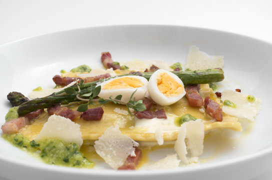 quail eggs and asparagus pasta on a white plate