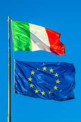 Italy flag and Europe flag waving together in isolated the blue sky background. Concept for financial treated, unique currency and financial bond.