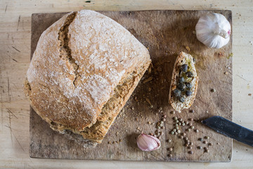 "Pane Brutto" or " Ugly bread"is a  tuscanian bread  with an irregular form and no clear rule about how to made it, looked from above on a wooden cutting board.