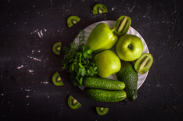 Green fruits and vegetables on a dark background