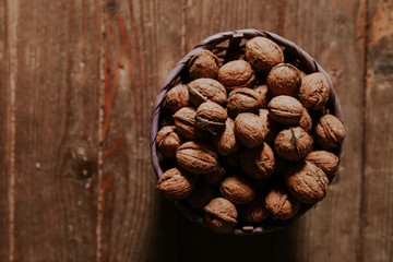 Whole walnuts on rustic old wooden floor, shot in natural light. Concept of healthy organic food.