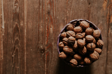 Whole walnuts on rustic old wooden floor, shot in natural light. Concept of healthy organic food.