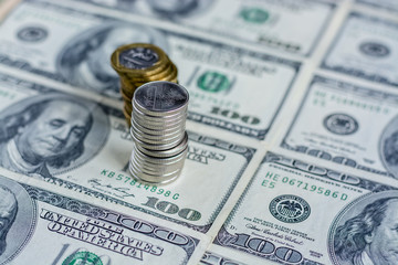 Fototapeta premium A column of coins on a hundred dollars background 