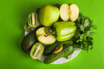 Green fruits and vegetables on a bright background