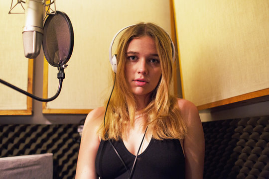 Portrait of young woman standing in recording studio