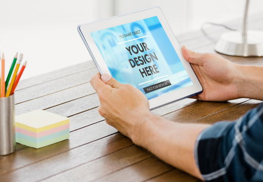 User at Wooden Desk with Tablet Mockup 1