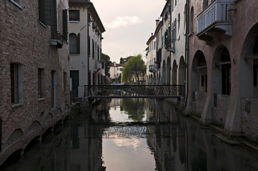 Fototapeta na wymiar Reflections on Buranelli canal at sunset in Treviso. Italy