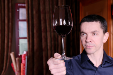 Handsome man holding glass of red wine