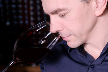 Handsome man tasting red wine