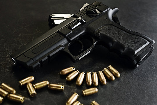 handgun with ammunition on a black surface
