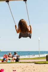 Girl swinging on swing-set.