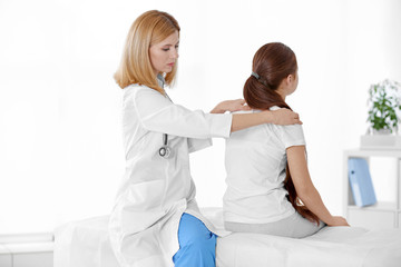 Incorrect posture concept. Physiotherapist examining and correcting girl's back