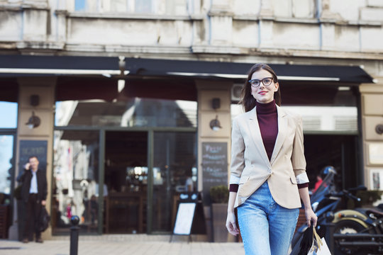 Smiling Woman With Shopping Bags Walking On The Street