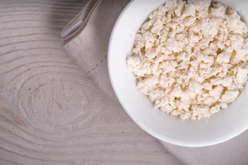 Cottage cheese in a ceramic bowl on a white napkin diagonal