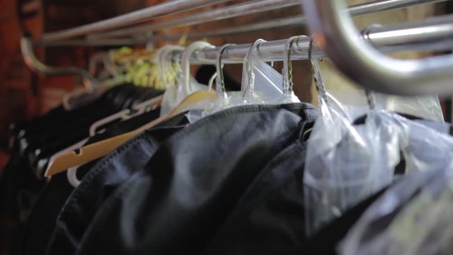Suits in travel bags hanging on a rack