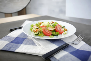Food photography concept. Plate with delicious salad and napkin on table
