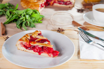 Piece of sweet pie, tart, cake with jellied fresh strawberries on the white plate on the wooden served table. Close up, Selective Focus