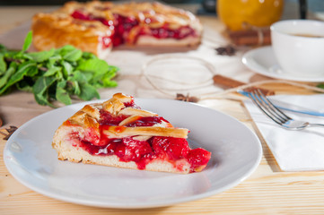 Piece of sweet pie, tart, cake with jellied fresh strawberries on the white plate on the wooden served table. Close up, Selective Focus