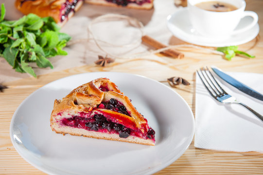 Piece of sweet pie, tart, cake with jellied fresh berries on the white plate on the wooden served table. Close up, Selective Focus