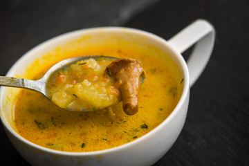 cream soup with mushrooms chanterelles and herbs black stone background