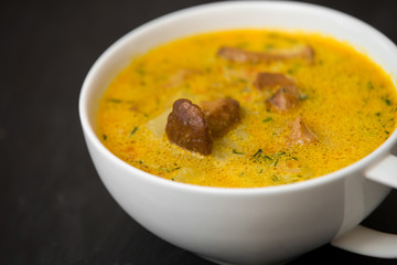 cream soup with mushrooms chanterelles and herbs black stone background