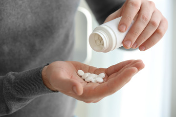 Young man with pills, closeup