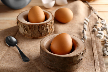 Wooden stands with Ester eggs on linen tablecloth
