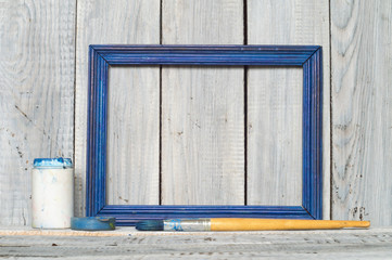 Blue frame, paint and brush on white boards background