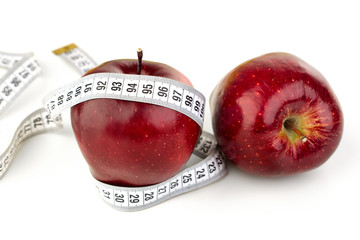 Two ripe red apples and a tape measure