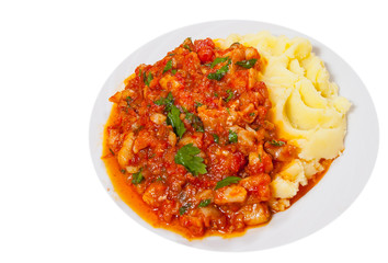pieces of fish in tomato sauce with mashed potatoes. top view. isolated on white